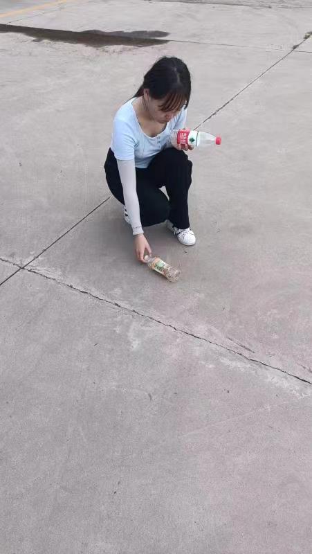 (图为王辛月同学在进行社区环境清洁工作)