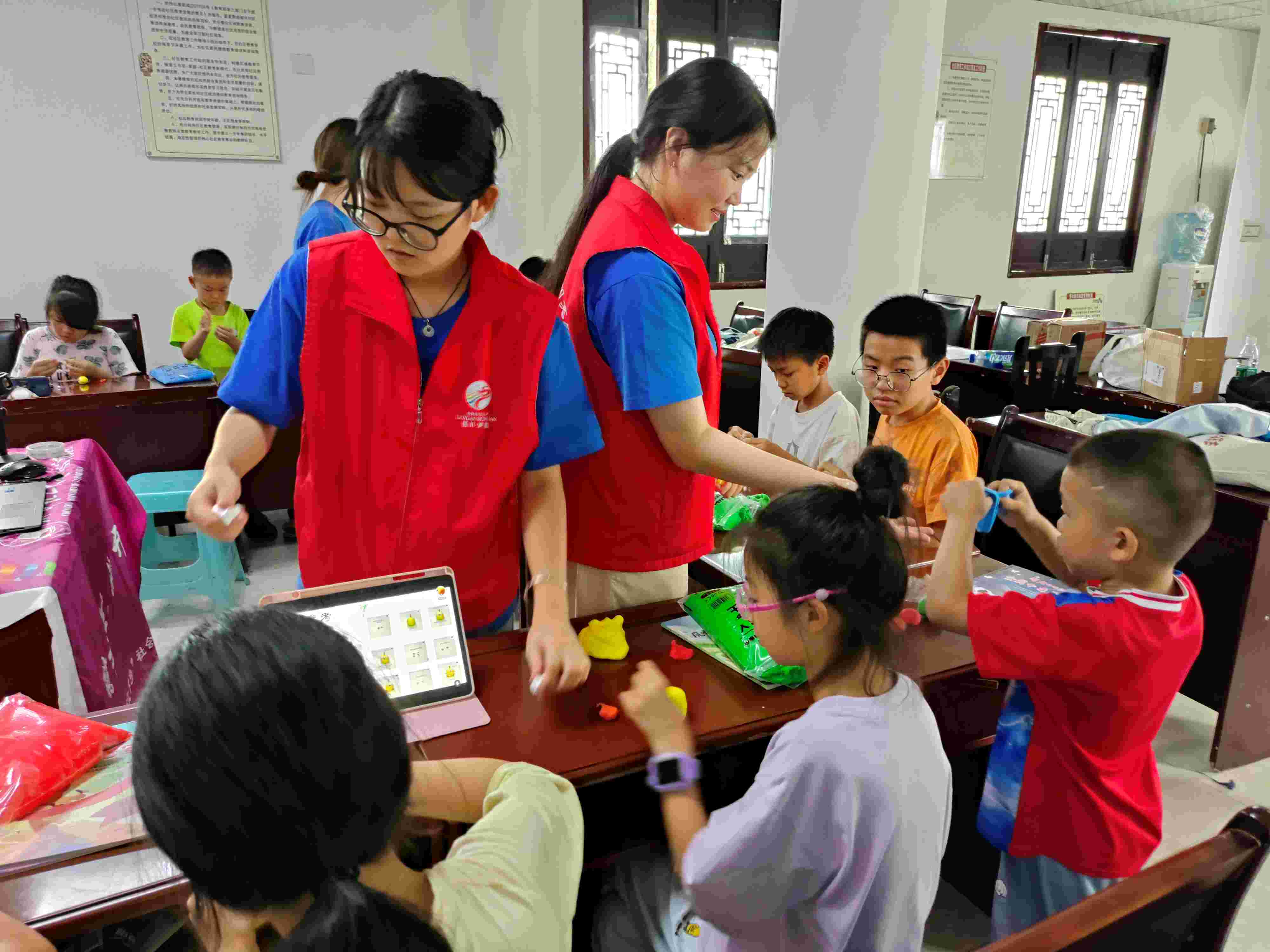 图为团队成员向孩子们进行手把手教学。 李欣 供图