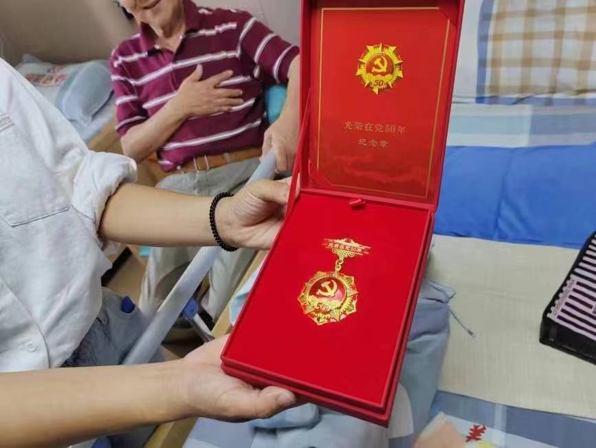 图为乔亚光老人被授予的入党50周年纪念章