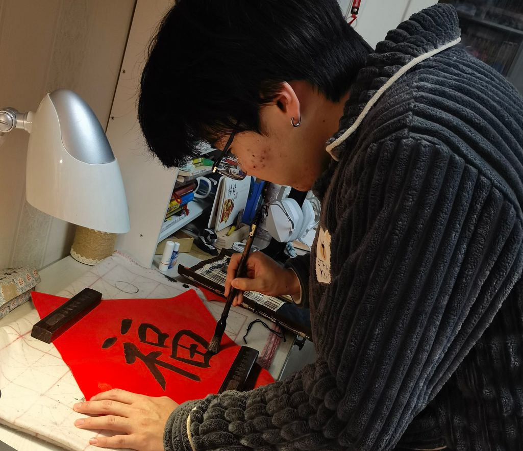 图为同学体验写春联。马誉恒供图