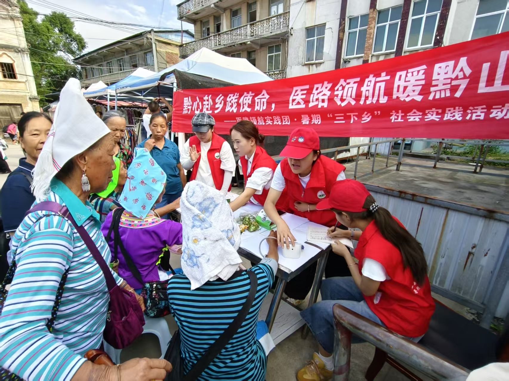 图为志愿者为村民量血压建立健康台账