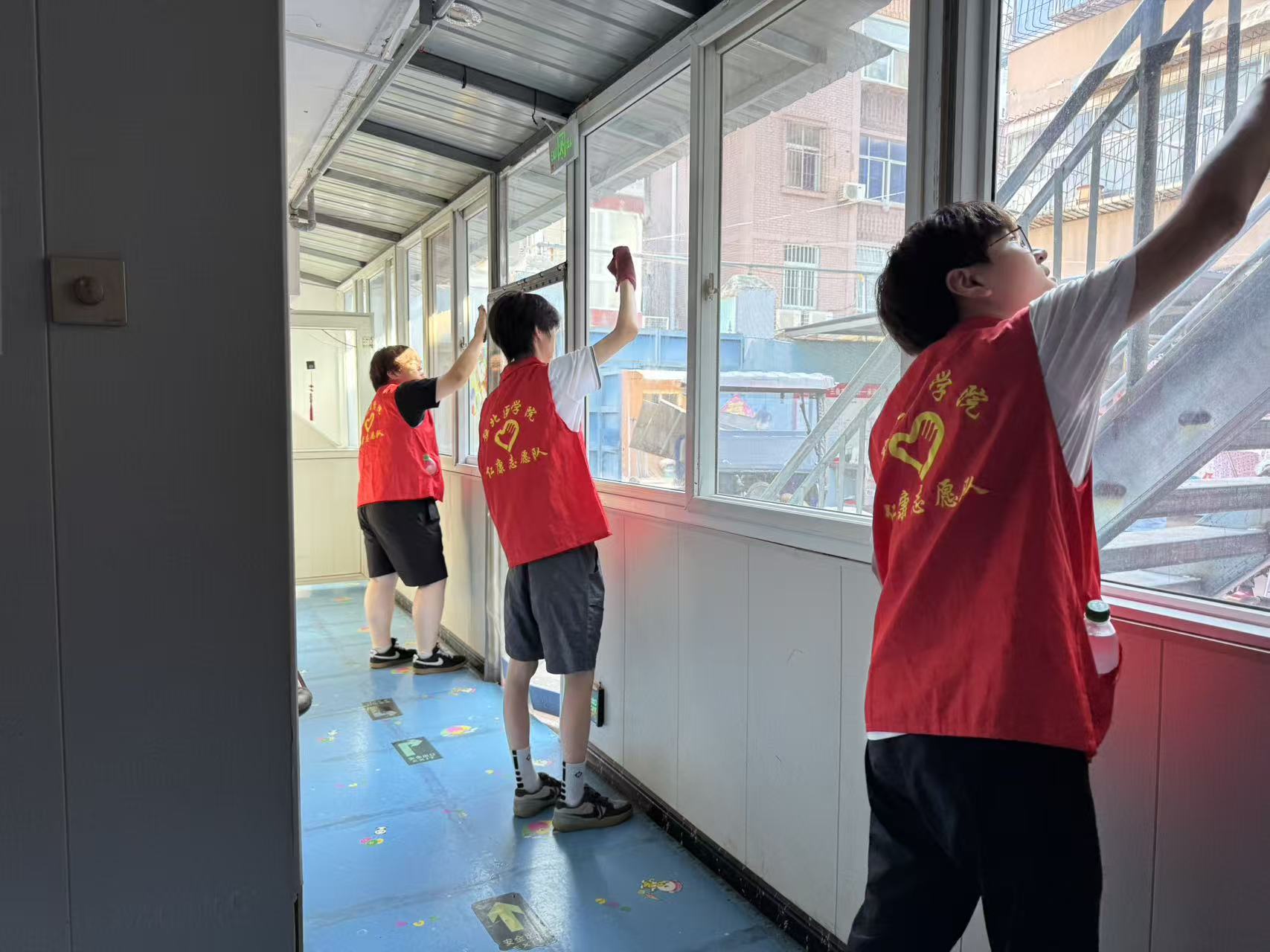 志愿者擦拭养老院走廊窗户,清洁公共区域环境 夏思禹 摄