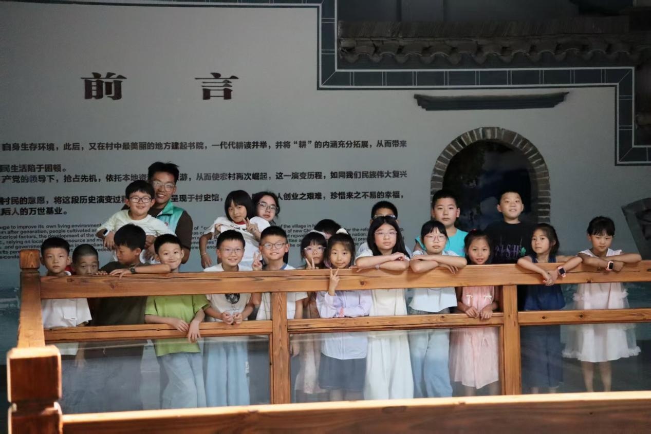图为志愿者与参与红色课堂的乡村少年在宏村村史馆合影留念。