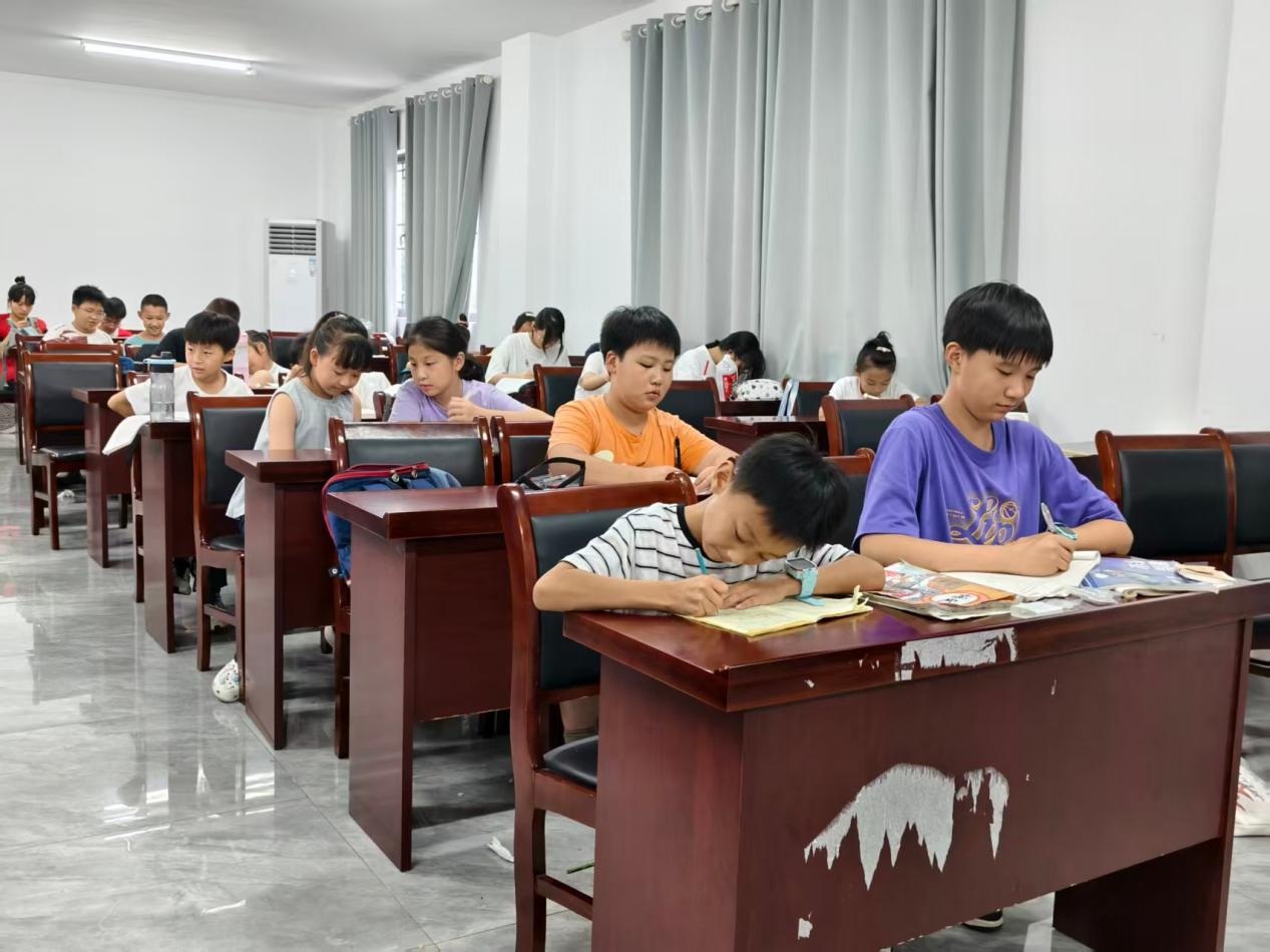 图为乡村少年认真书写梦想心愿卡,记录个人奋斗目标与成长期盼。