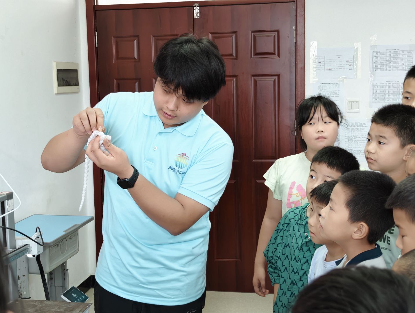 志愿者向孩子们展示 3D 打印成品,结合实物讲解三维模型从数字设计到实体成型的全过程,让科技知识看得见、摸得着,把趣味科创课堂带进乡村爱心托管班。