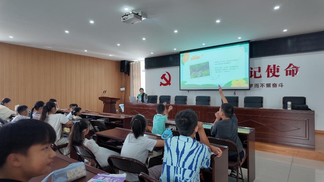 图为树叶科普手工课堂互动环节,孩子们踊跃举手,积极回答支教队员提出的自然知识问题。