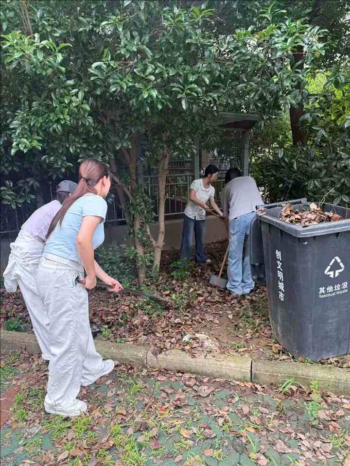 队员在社区工作人员指导下清扫沉积落叶
