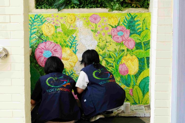 图为彩绘组绘制花草彩绘,以缤纷植物图案传递自然科普知识,为遂溪青少年宫增添童趣色彩