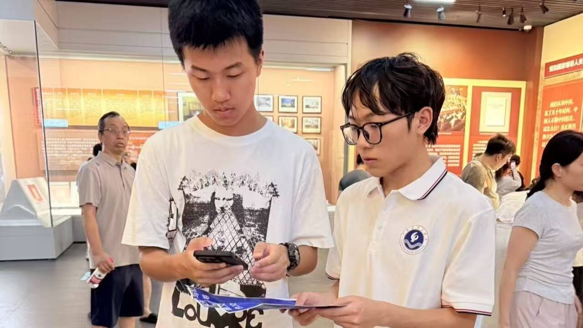 图为队员对游客进行线上的问卷调查