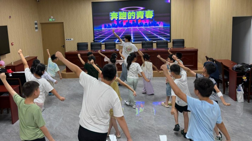 少儿舞蹈课堂气氛轻快活泼,队员带领孩子们跟随音乐伸展四肢,反复练习基础律动动作,在舒展的肢体活动中感受舞蹈乐趣。