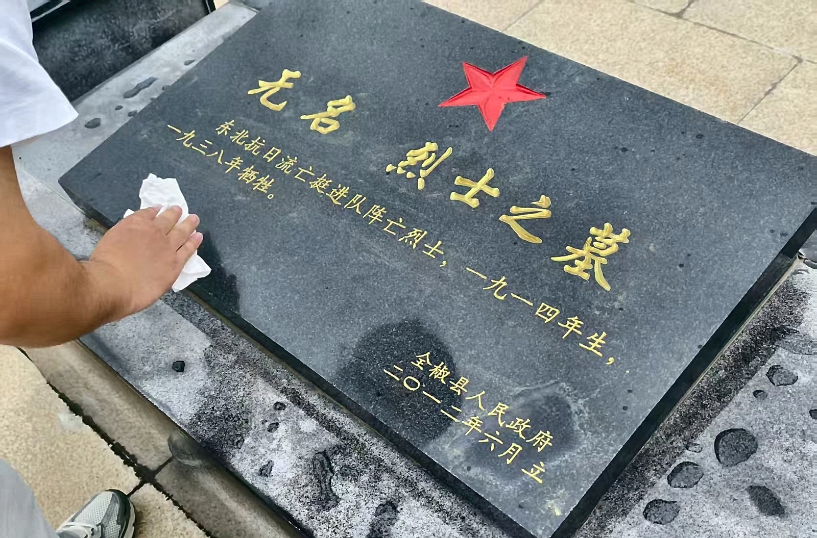 实践队员轻轻擦拭烈士墓碑