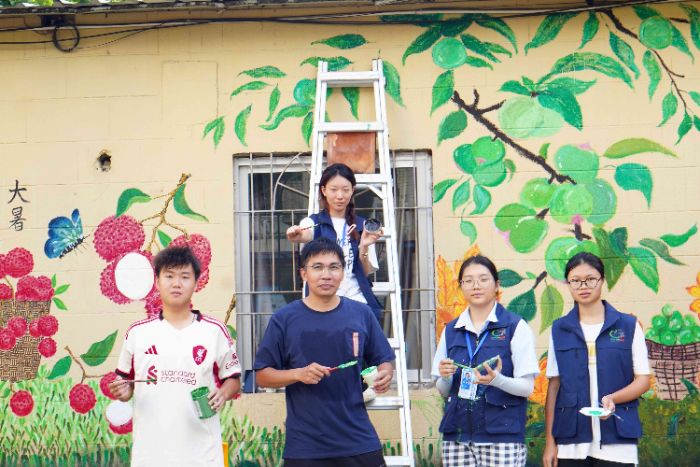 图为师生携手绘乡土,墙绘融合二十四节气文化与遂溪仙品荔特色物产,以彩绘讲好本土故事