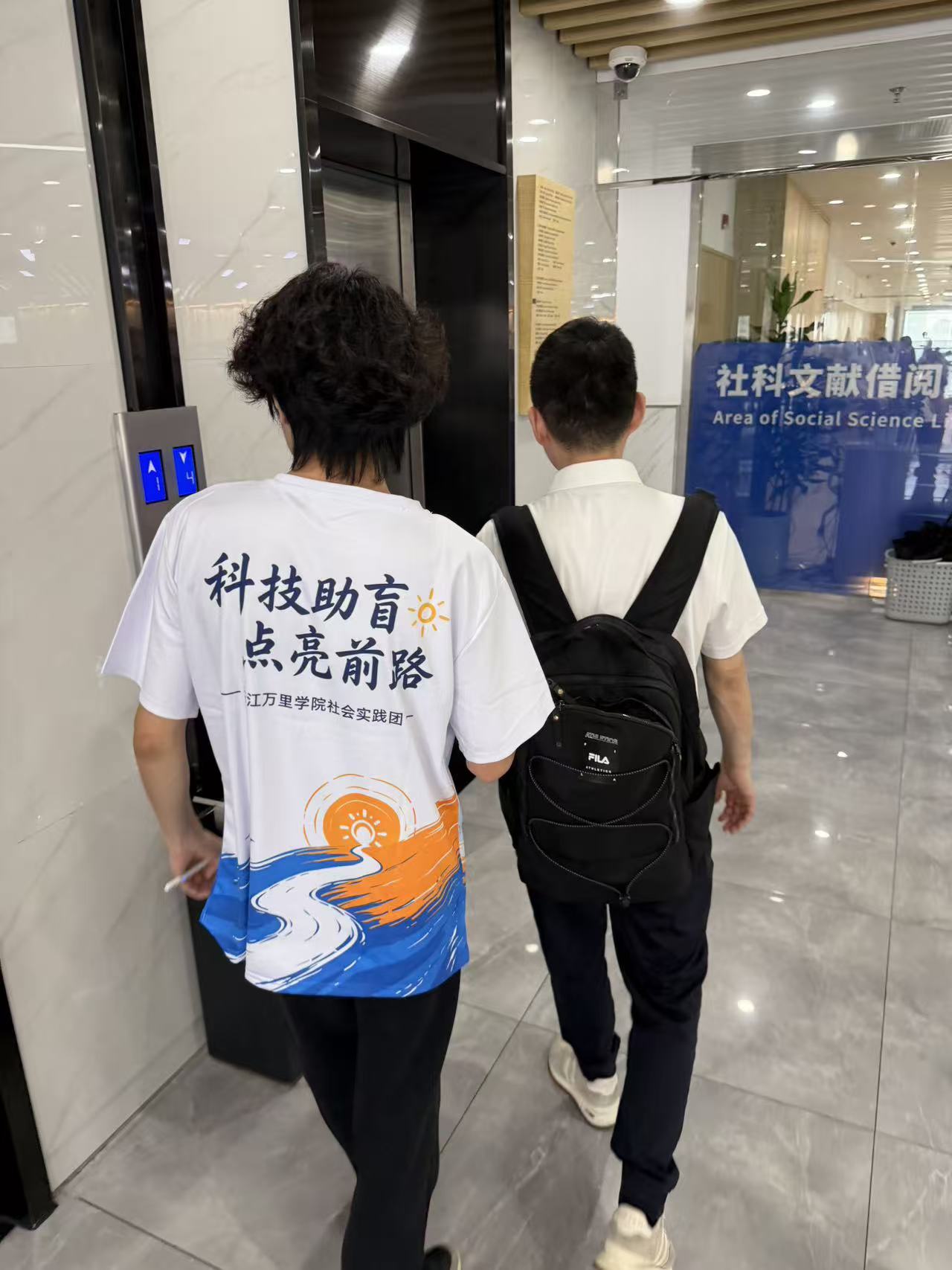 【图片2:实践团成员陪同视障人士在公共空间行走】