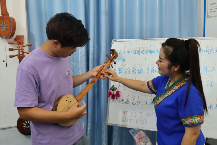 非遗传承人吴柳桃指导队员按弦把位