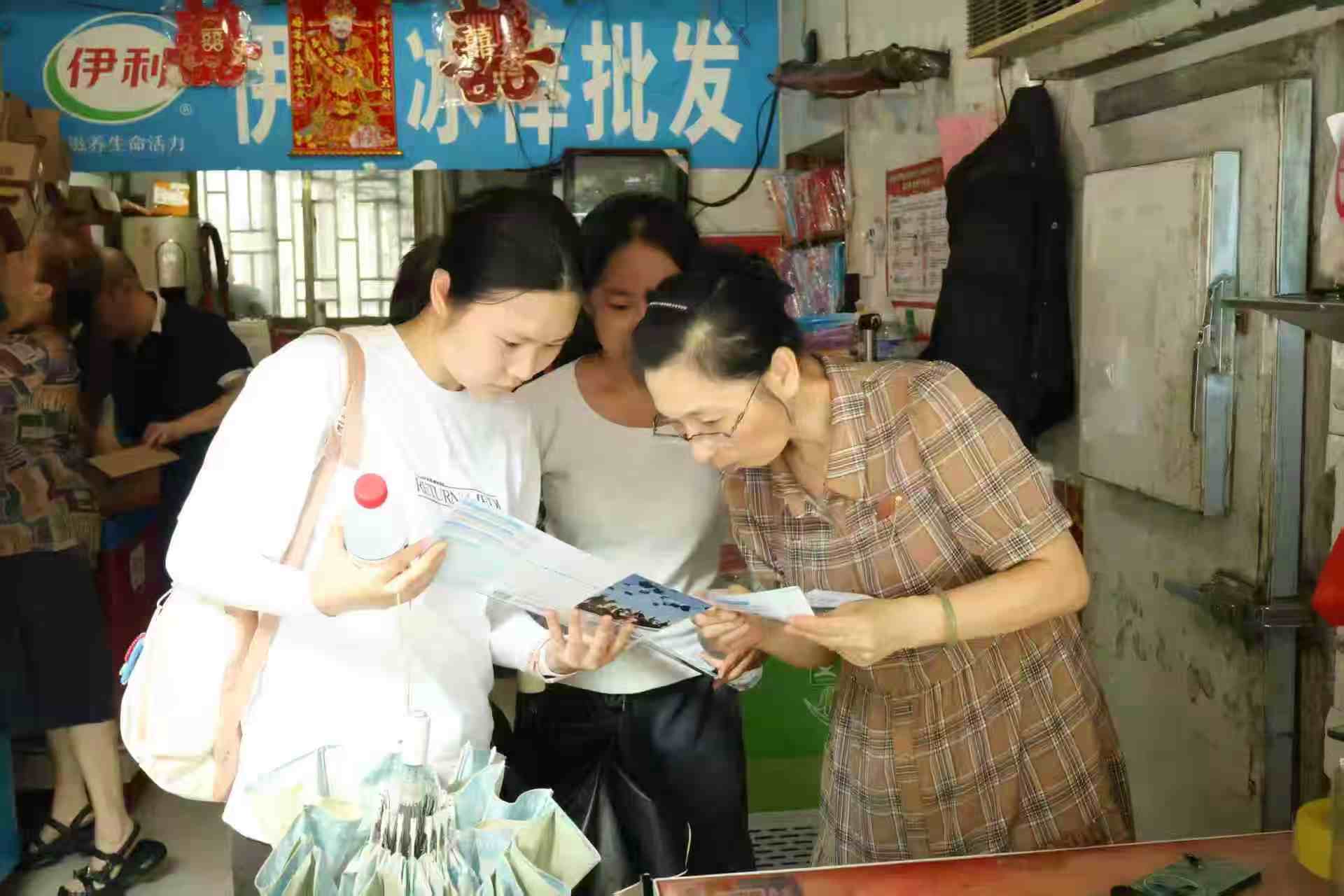志愿队成员向居民宣传资助政策+颜玮雯摄