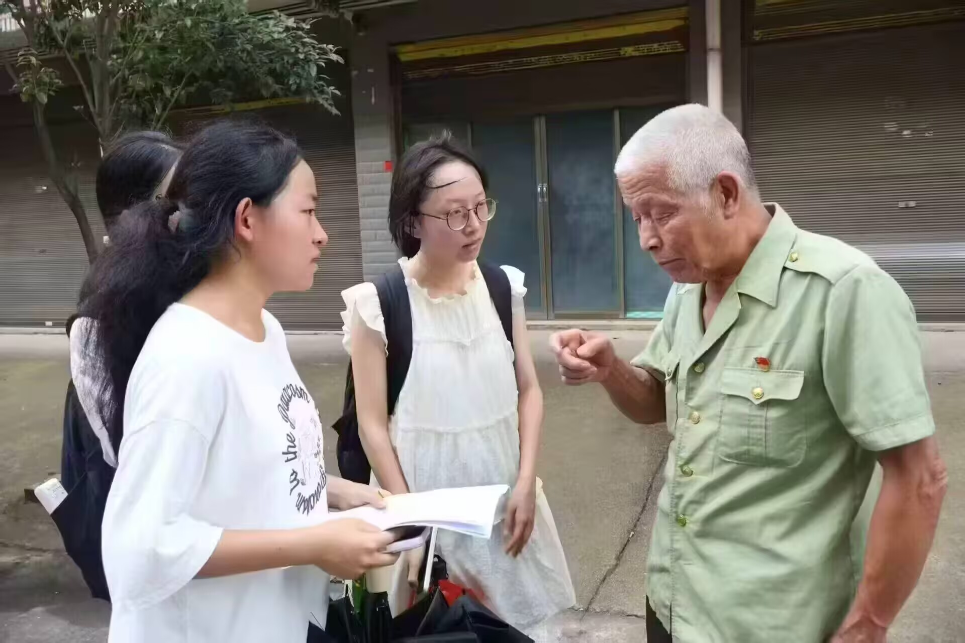 志愿者成员与当地老人交谈+颜玮雯摄