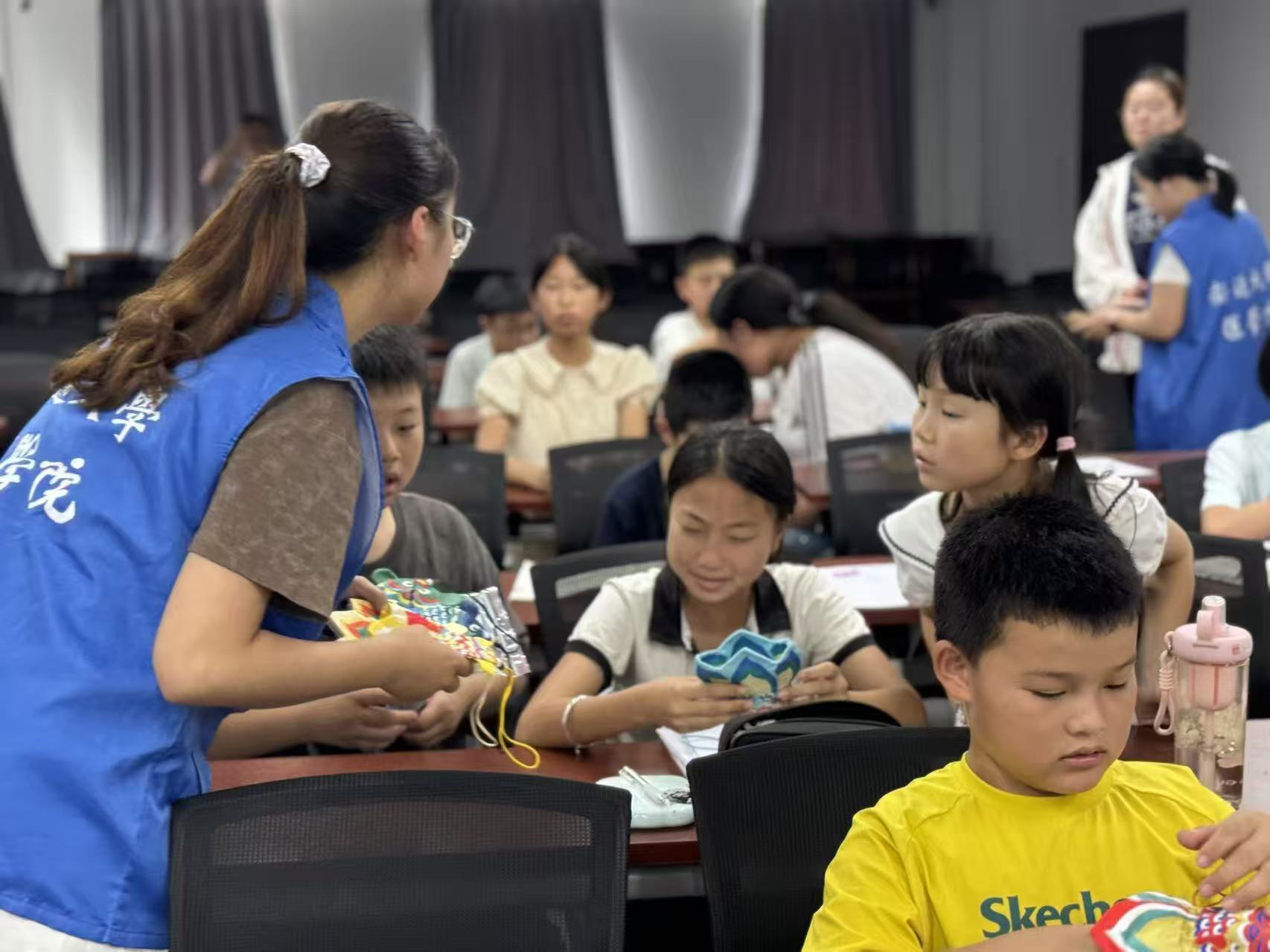 志愿者引导社区儿童制作驱蚊香包 高乐涵摄