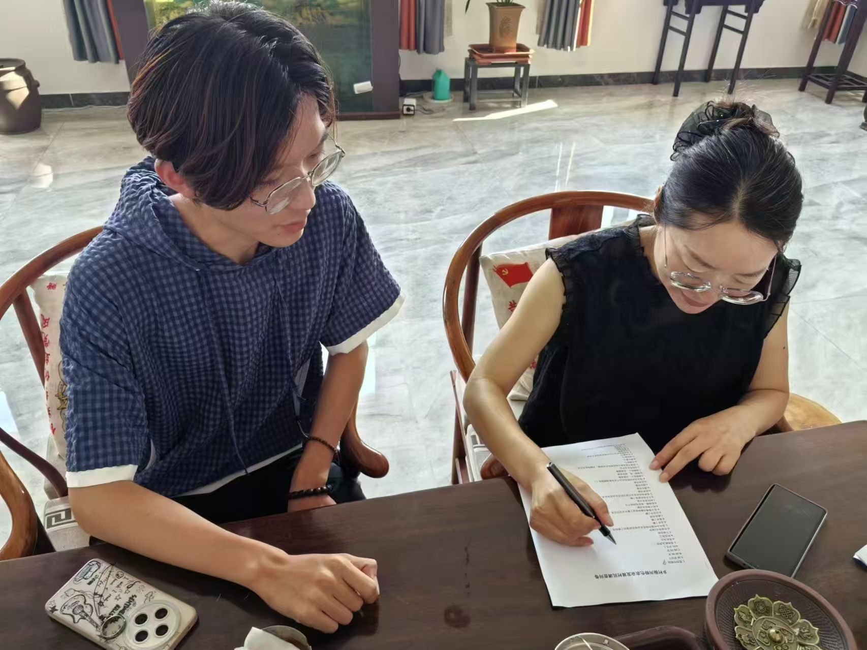 图为团队成员引导村民填写调查问卷