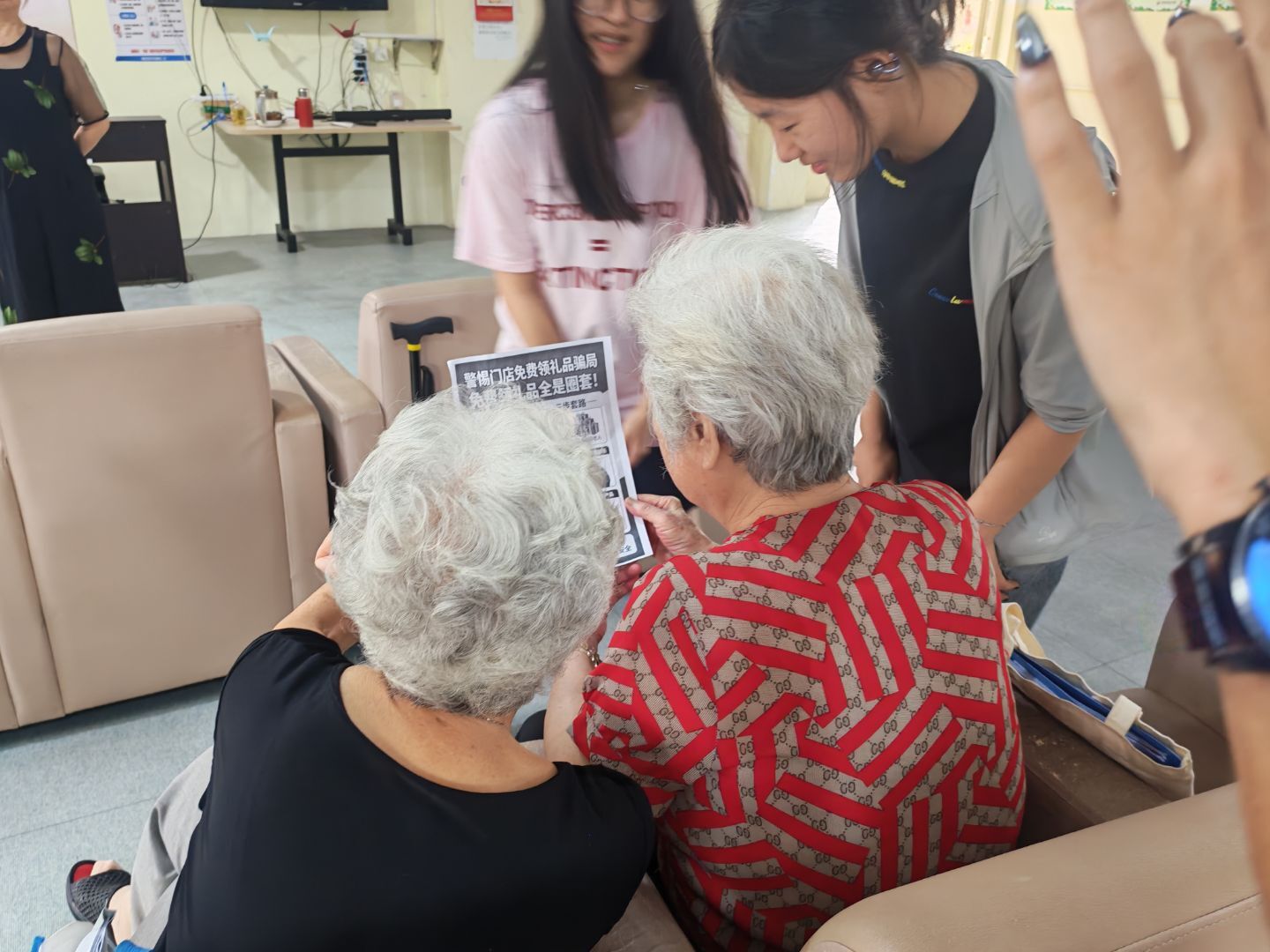 图2:团队成员为老人仔细介绍免费领礼品、线下门店诱导骗局
