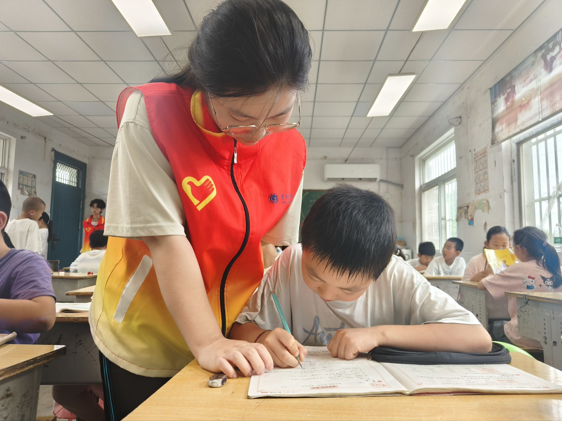 图 10 志愿者一对一辅导学生习题,耐心解答孩子学习上的疑问。郭楠 供图
